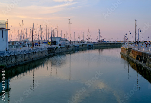 Senigallia, Italy: view of the harbor on the sunset over the yachts and boats. Urban view. City postcard. Marina at dusk
