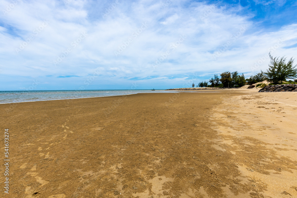 Marée basse avec palmiers et bateau de pêcheur en Thaïlande