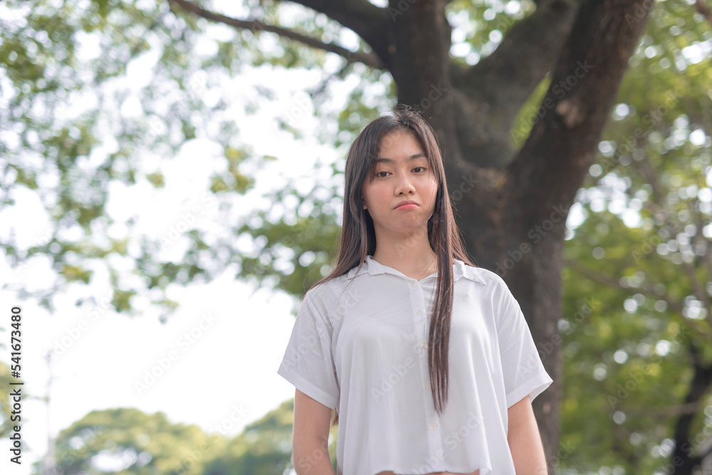 A Southeast Asian girl frowning at the camera feeling sad about the environmental issues. A Southeast Asian girl frowning at the camera feeling sad about the environmental issues.