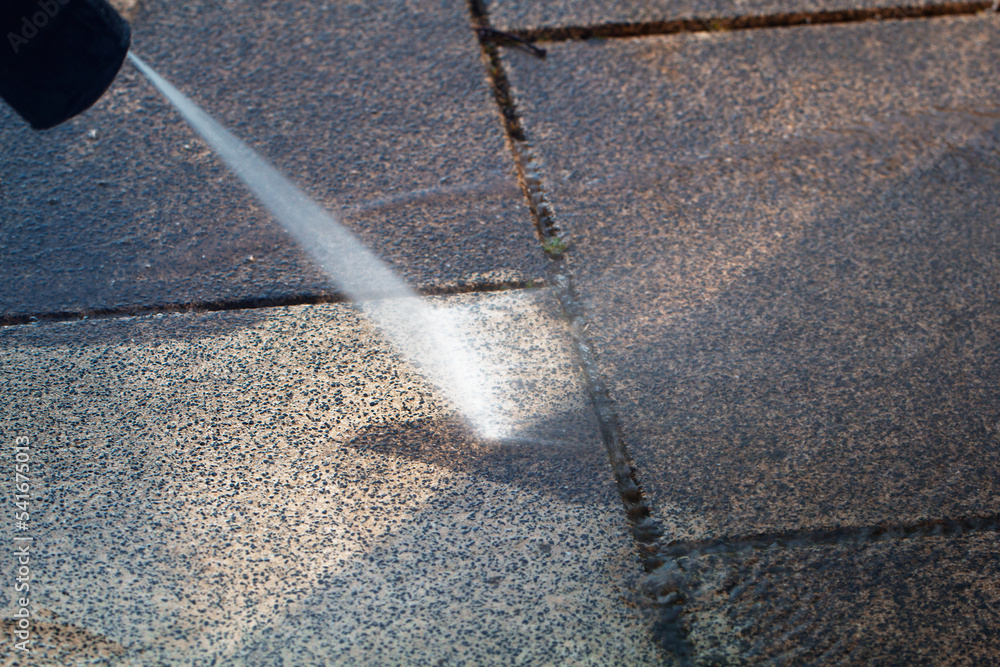 Power cleaning dirty floor, paving slabs with high pressure water jet