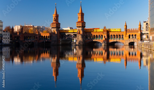 Photography Berlin panorama with “Oberbaum bridge “ and yellow underground railway train crossing River Spree, which was the frontier between East and West Germany
