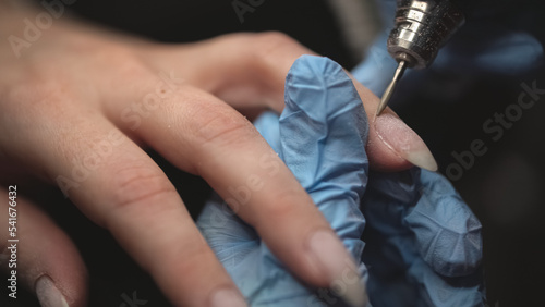 manicurist using nail polish remover