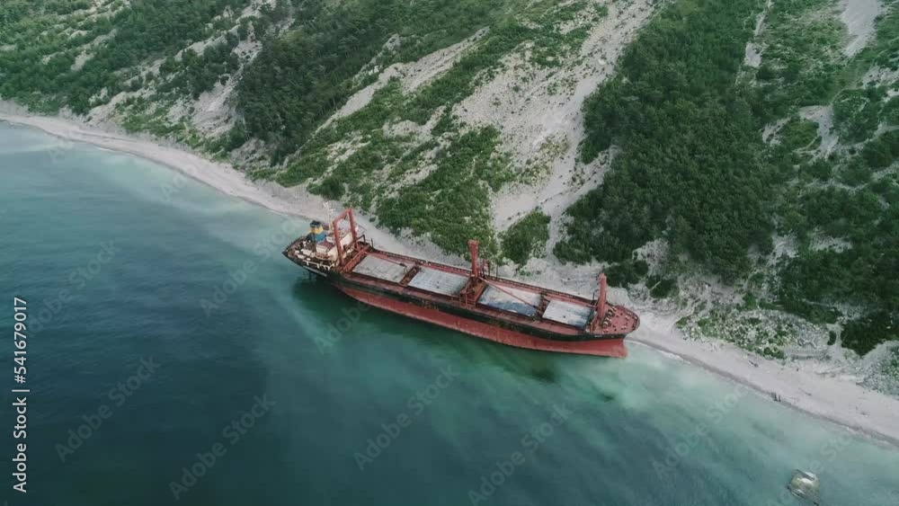 Aerial view of abandoned cargo ship. Bulk carrier ran aground after the storm. Dry cargo ship RIO stands ashore. Aerial view of abandoned cargo ship. Bulk carrier ran aground after the storm. Dry cargo ship RIO stands ashore.
