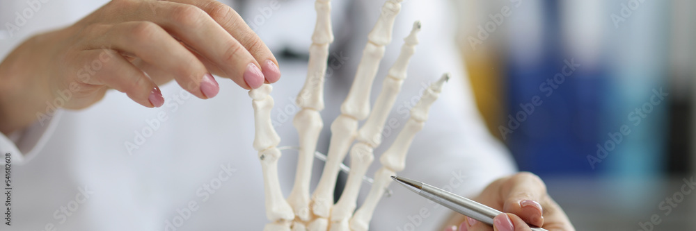 Female scientist explore human skeleton hand model, laboratory and medical anatomy science