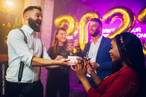 Multiracial couple exchanging gifts for birthday party or new years eve