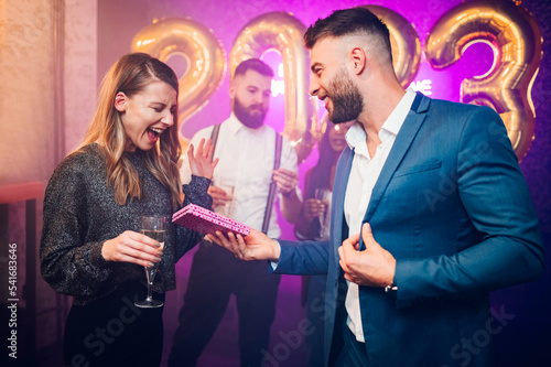 Couple exchanging gifts for birthday party or new years eve in the club