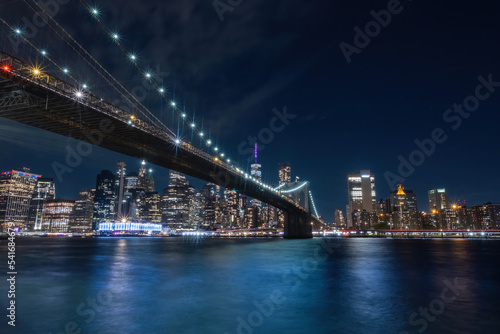View of New York City - beautiful landscape  from Brooklyn Bridge Park  waterfront at night over bridge