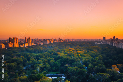 Aerial view of the Central park in Manhattan, New York with golf fields and tall skyscrapers surrounding the park. Sunset view.