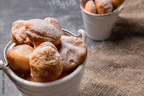 Baursak - Traditional Kazakh Asian in a white bucket. Beautiful presentation of the food. yeast dough balls, prepared on a pan with oil and sprinkled with powdered sugar photo