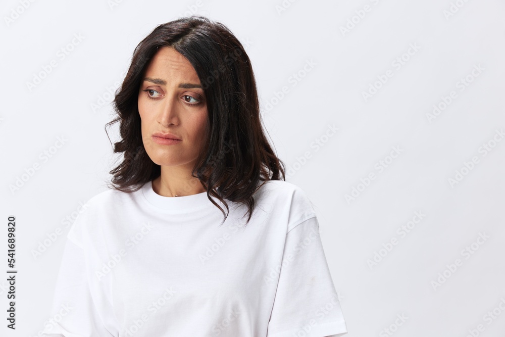 Woman headache and sadness, stress and depression, woman in a white t-shirt on a white background illness, copy space Woman headache and sadness, stress and depression, woman in a white t-shirt on a white background illness, copy space