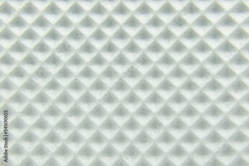 White foamlike square texture with small grooves and dirt