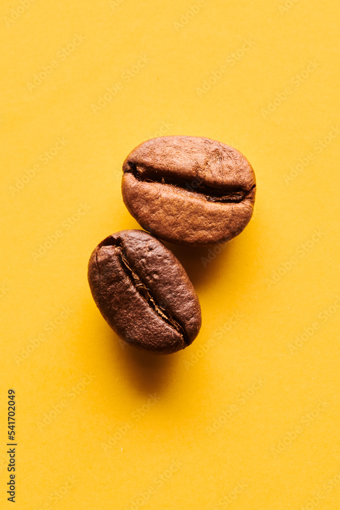 Obraz premium Roasted coffee beans on yellow background
