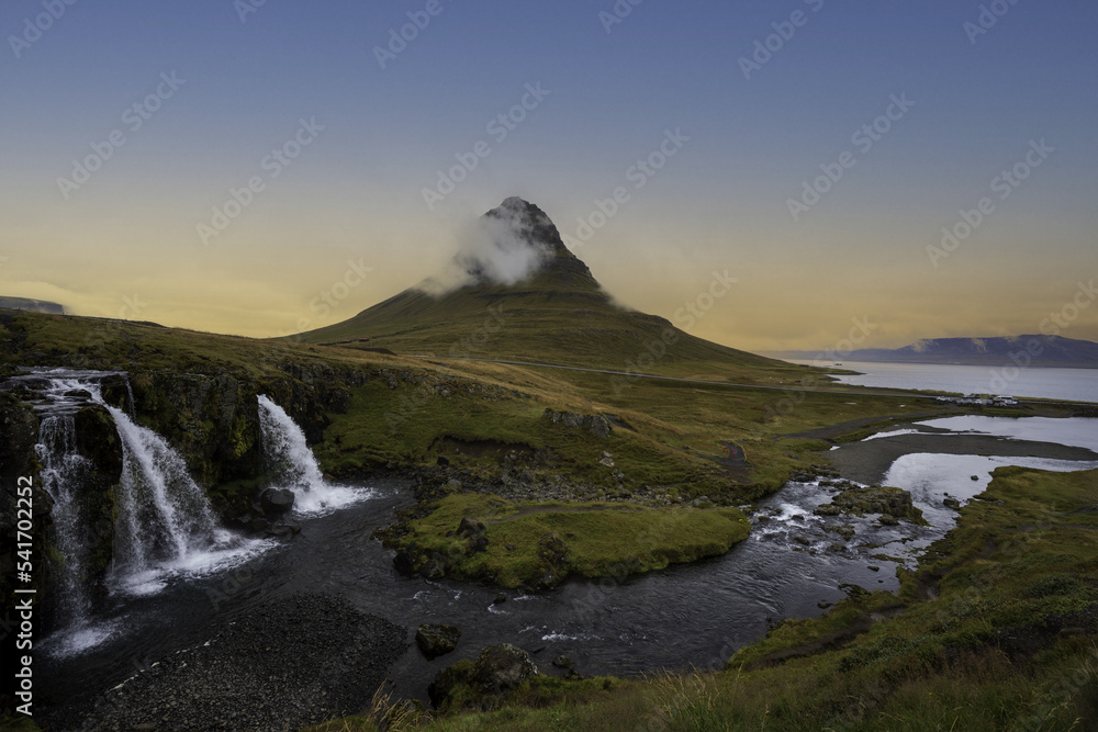 sunrise on a mountain with green meadows and waterfalls overlooking the sea in autumn and winter