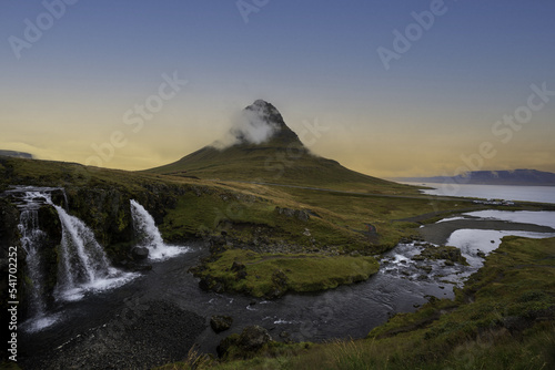 sunrise on a mountain with green meadows and waterfalls overlooking the sea in autumn and winter