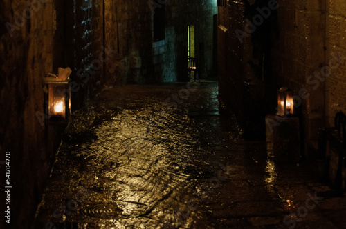 Hanukkah menorahs glow on a rainy winter night  in the Old City of Jerusalem during the celebration of the Festival of Lights in Israel.