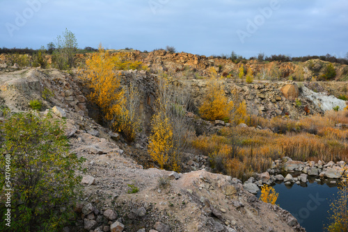 Flooded granite quarry White rocks near village Aktove, Ukraine. Colorful leaves of trees in the autumn landscape, colors of leaf-fall.
