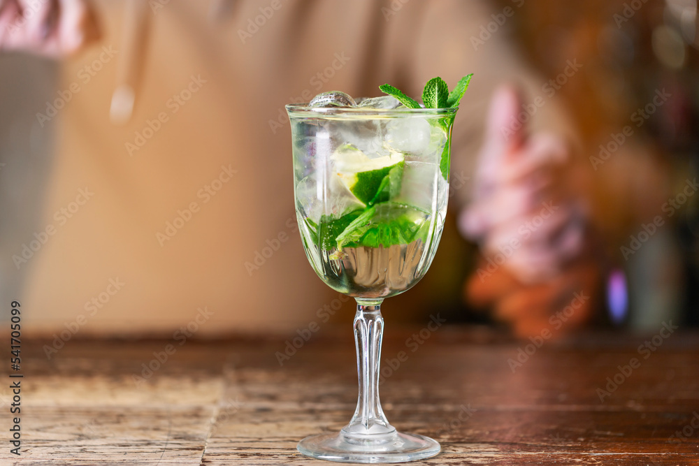 Expert barman is making refreshing cocktail at night club. Expert barman is making refreshing cocktail at night club.