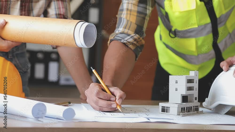 Construction engineer working at blueprint to build large commercial buildings in office. Engineering tools and construction concept. Construction engineer working at blueprint to build large commercial buildings in office. Engineering tools and construction concept.
