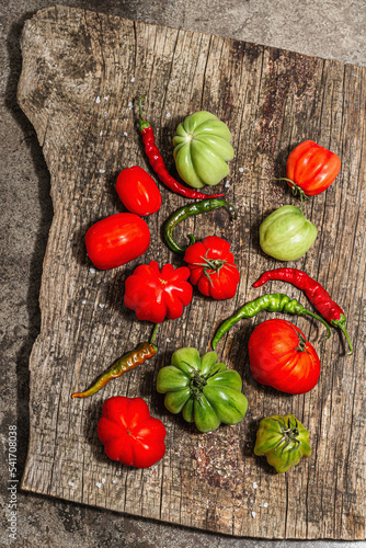 Green and red ribbed tomatoes on a vintage wooden stand. American or Florentine variety