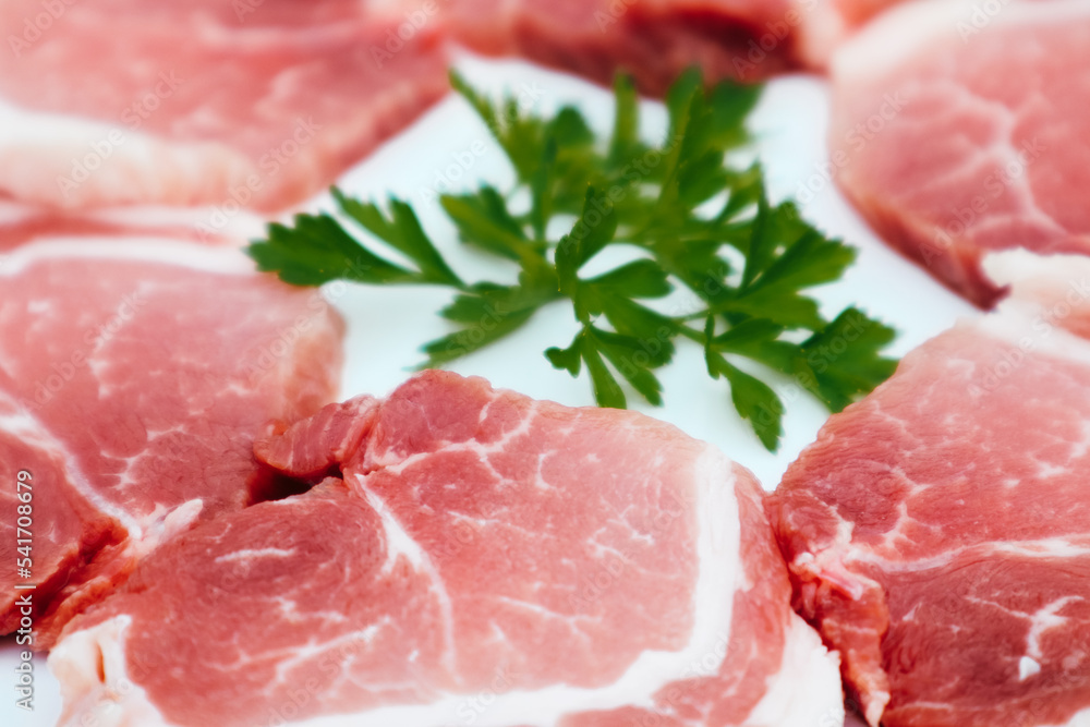 Raw Pork Slice in White Round Plate decorated with parsley. Fresh raw pork. Raw Pork Slice in White Round Plate decorated with parsley. Fresh raw pork.