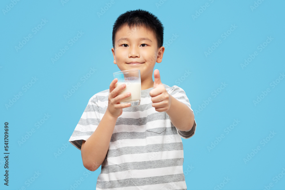 Kid holding milk glass with smile and thumb up, wearing tshirt Kid holding milk glass with smile and thumb up, wearing tshirt
