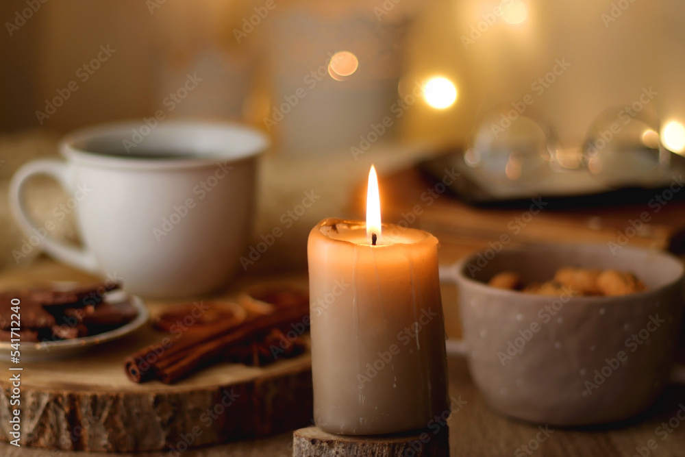 Bowl of cookies, cup of tea or coffee, chocolate, spices, knitted blanket, books, glasses and candle on the table. Cozy hygge atmosphere at home. Selective focus. Bowl of cookies, cup of tea or coffee, chocolate, spices, knitted blanket, books, glasses and candle on the table. Cozy hygge atmosphere at home. Selective focus.