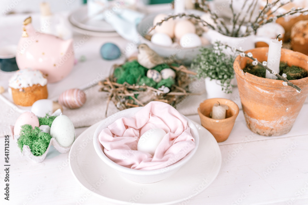 happy easter and spring holidays time. festive tablescape set decor. traditional dinner food easter eggs and baked cakes on table at home. rabbit and willow. pale pop pastel blue and pink color happy easter and spring holidays time. festive tablescape set decor. traditional dinner food easter eggs and baked cakes on table at home. rabbit and willow. pale pop pastel blue and pink color