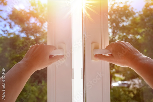 man at home open window on a sunny day. manual open white pvc plastic window at home