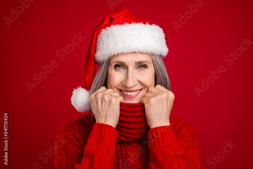 Photo of cheerful nice grandma hold scarf enjoy comfy warmth wear hat sweater isolated red color background