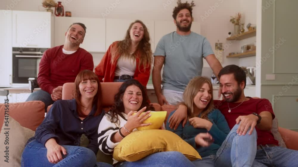 group of friends watching a funny movie TV, eating popcorn and laughing group of friends watching a funny movie TV, eating popcorn and laughing