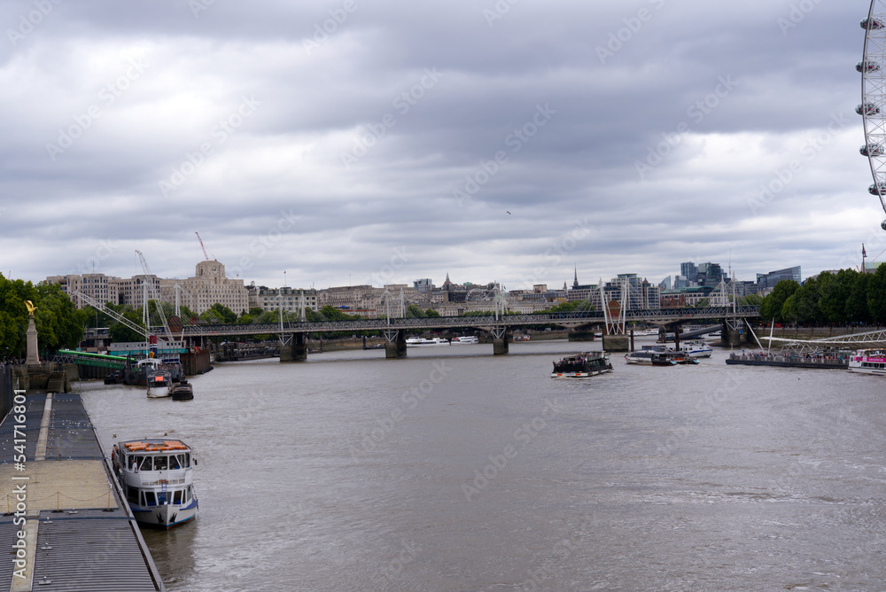 Hungerford railway bridge and Golden Jubilee Bridges with pedestrians crossing at City of Westminster on a cloudy summer day. Photo taken August 3rd, 2022, London, United Kingdom.