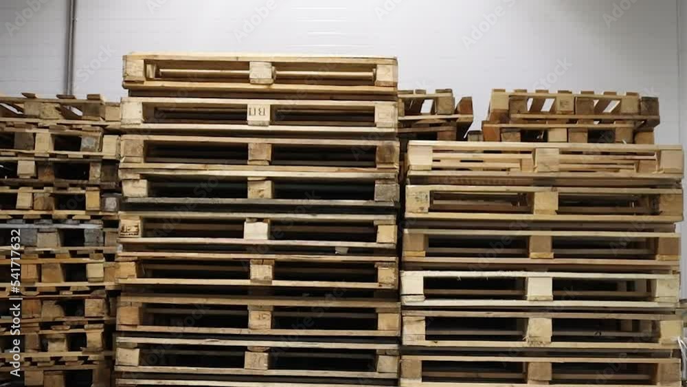 A lot stacks of used wooden pallets of euro type on warehouse is ready for recycling. Industrial background. Close-up. A lot stacks of used wooden pallets of euro type on warehouse is ready for recycling. Industrial background. Close-up.