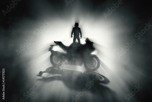 Silhouette of a motorcycle rider with a helmet and defocused race motorcycle wit Fototapet