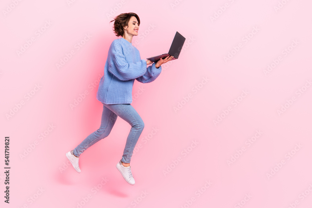 Full length profile photo of energetic attractive lady hold use wireless netbook isolated on pink color background Full length profile photo of energetic attractive lady hold use wireless netbook isolated on pink color background