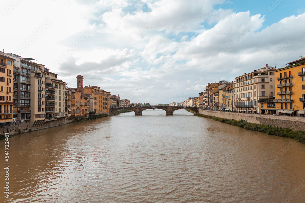 Beautiful vintage city with a river, a bridge and ancient houses along the river in Florence, Italy