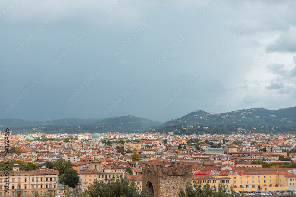 Cityscape with beautiful vintage buildings with red roofs with cloudy sky in Florence, Italy