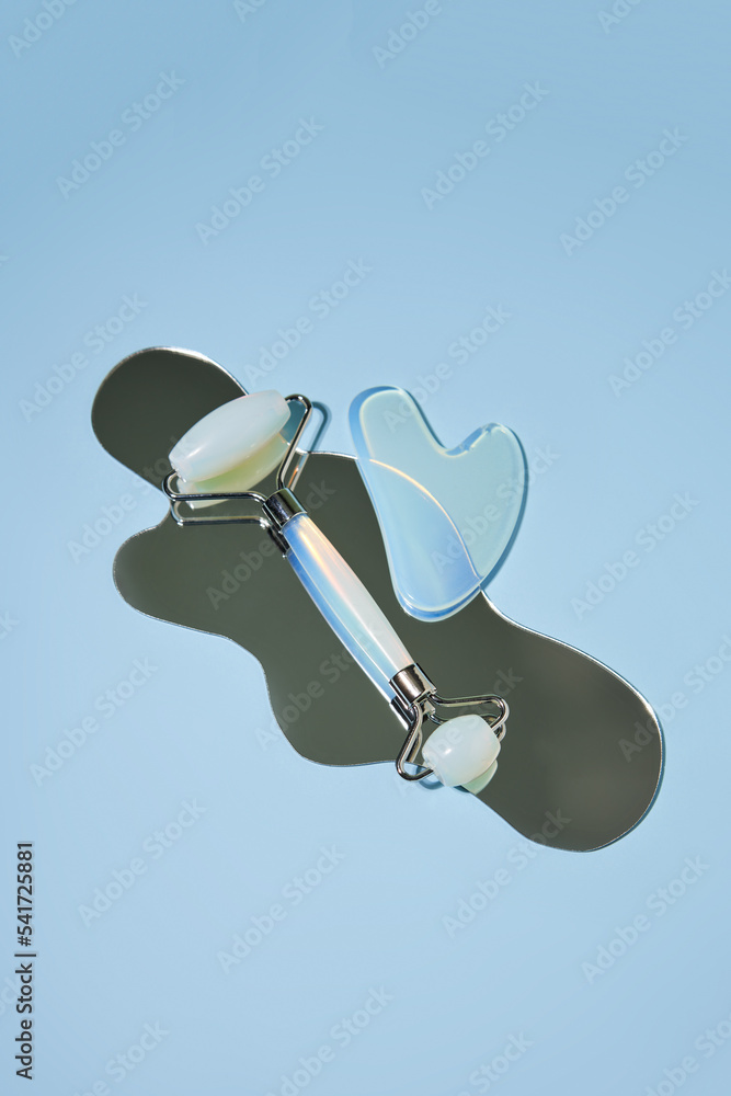 Blue jade face roller and Gua Sha scraping for beauty facial massage therapy
