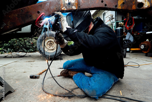 Vintage restorer, man welding old jeep truck