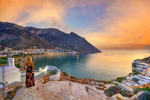 A woman looking from Agia Marina at Kamares beach of Sifnos island at sunset, Greece photo
