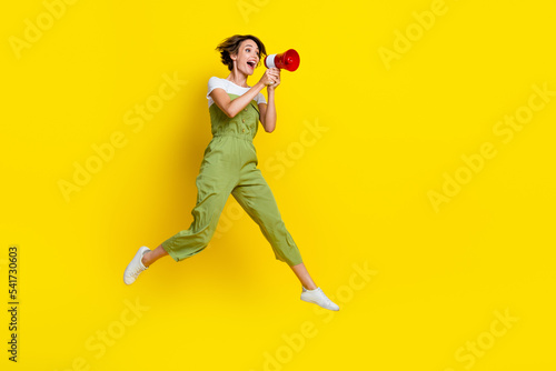Tableau sur toile Full length photo of young attractive screaming girl wear khaki overalls hold lo