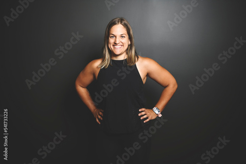 Happy sports woman celebrating his success over black background © Louis-Photo