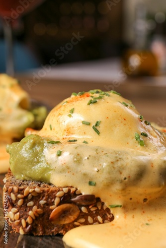 Foto American eggs benedict served with sauce, vertical