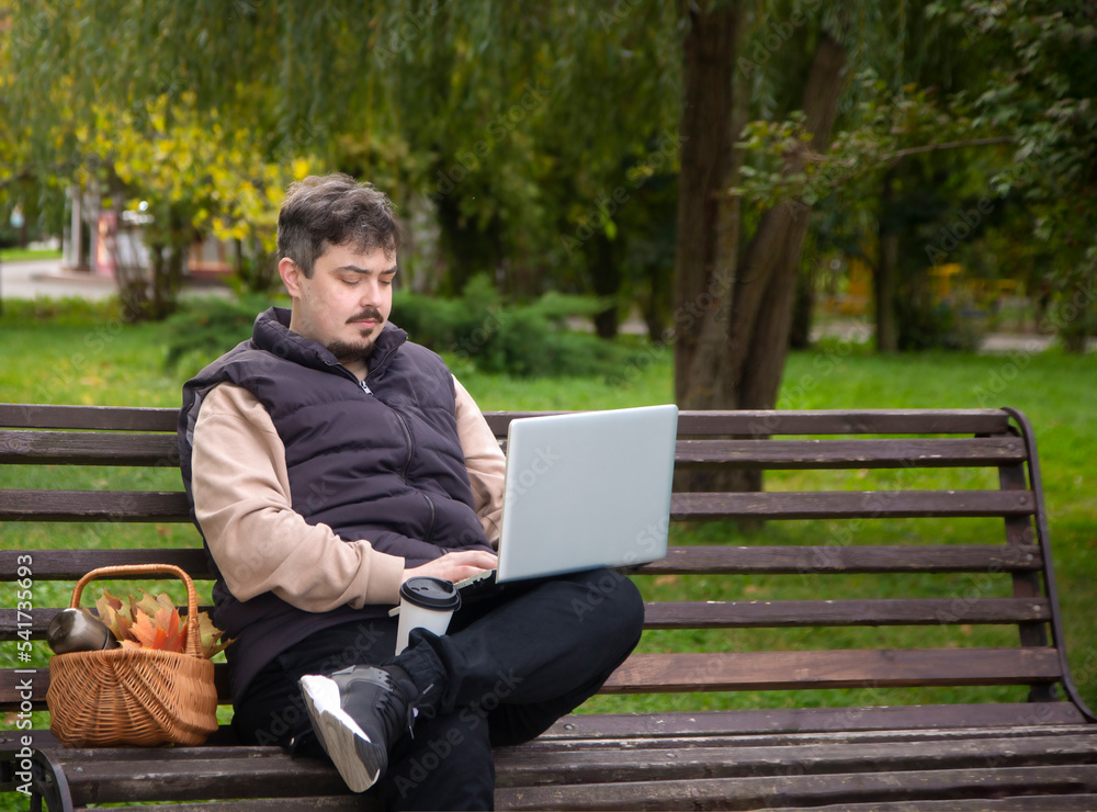 Fototapeta premium man sitting on bench with laptop