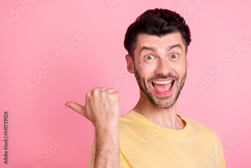 Portrait of funky impressed man stylish haircut yellow t-shirt indicating empty space open mouth isolated on pink color background