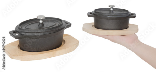 Small saucepan for serving food on a wooden stand. Isolated from the background