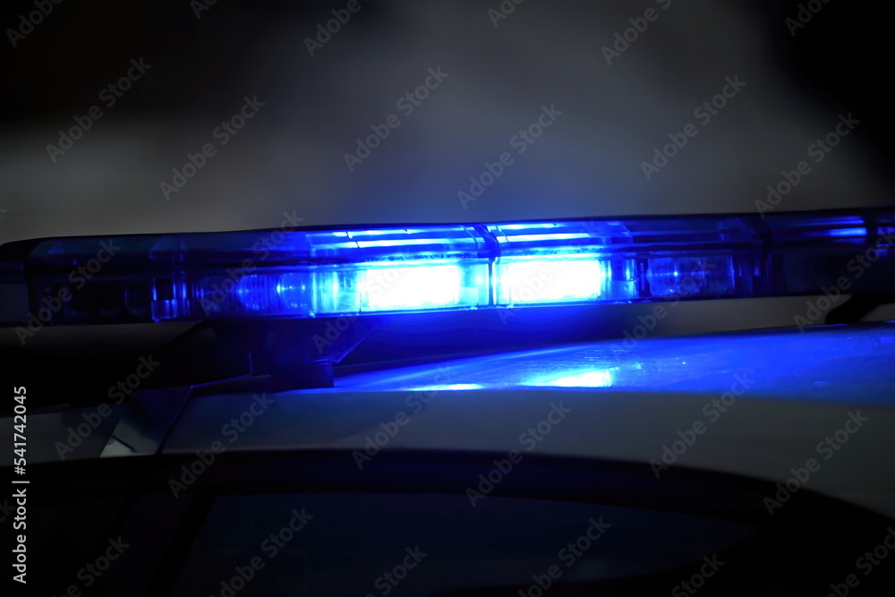 Police car with blue light on the street at night, selective focus Police car with blue light on the street at night, selective focus
