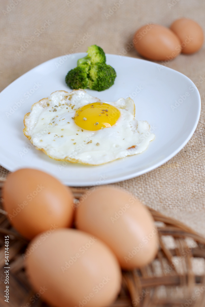 breakfast delicious fried sunny side up egg on a white plate with broccoli as a garnish breakfast delicious fried sunny side up egg on a white plate with broccoli as a garnish