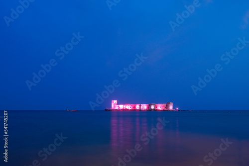A castle in the middle of the sea, illuminated at night in the blue hour. Mersin kız kalesi photo