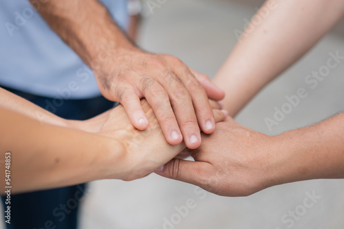 Group of diverse people stacking hands in the middle. People joining for cooperation success business. © kongga studio