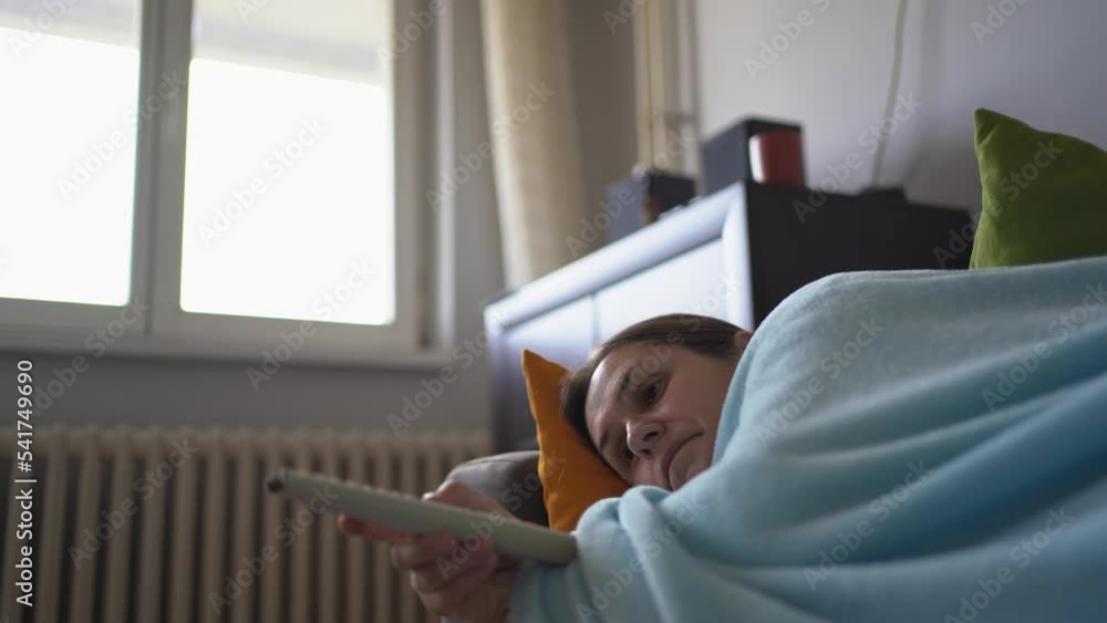 woman wrapped in blanket shivers with cold at home and watching television woman wrapped in blanket shivers with cold at home and watching television